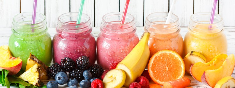 Mehrere Gläser mit verschiedenfarbigen Smoothies