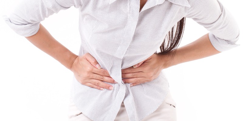 Frau hält sich den schmerzenden Bauch; Foto: 9nong, Shutterstock.com
