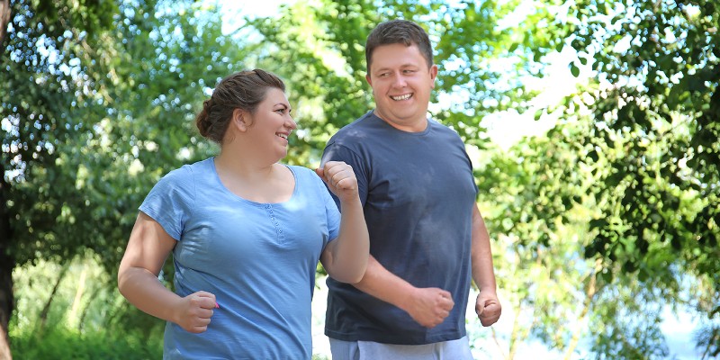 Eine Frau und ein Mann beim Walking im Wald; Foto: Africa Studio - Shutterstock.com
