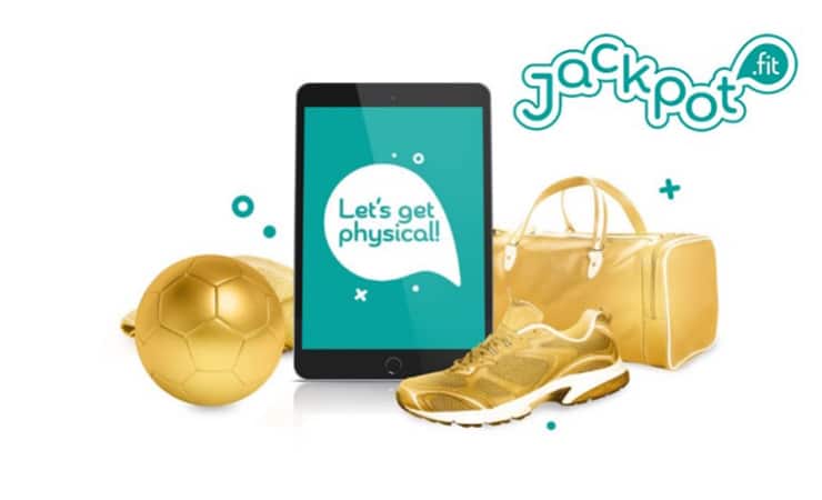 Das Jackpot.Fit Logo ist auf einem iPad zu sehen, der Hintergrund ist Türkis. Links daneben sieht man einen vergoldeten Ball und rechts daneben einen vergoldeten sneaker, und eine vergoldete Tasche.